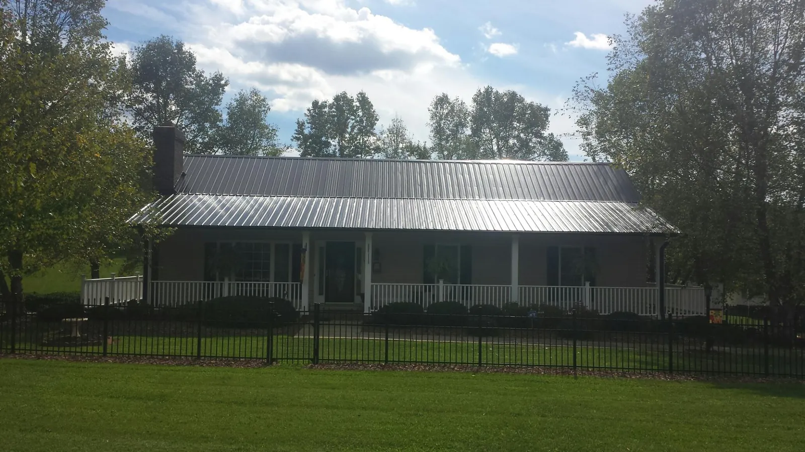 Gray metal roof on a brick ranch with a full width front porch — Gutter Guard Installation work by our crew in Tecate